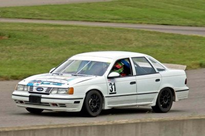 Watch Old Ford Taurus Pass Porsche, BMW, Pace McLaren On Race Track