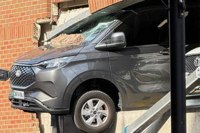 Pedestrians rushed to hospital after being hit by falling rubble when van ploughed through wall and was left dangling from car park building