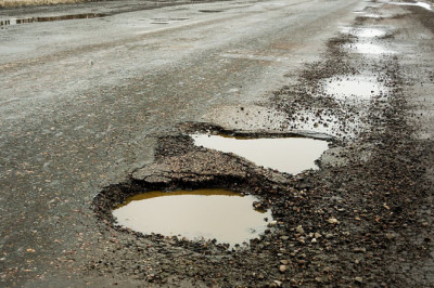 Wet weather causes surge in crashes across Britain as drivers hit hidden potholes