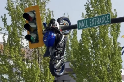 A Motorcycle Hit a Car. The Car Stayed on the Road. The Motorcycle Ended Up Hanging From the Traffic Light.